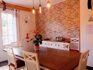 eine Küche mit einem Holztisch und einer Ziegelwand in der Unterkunft Le Clos des Passiflores - Bed and breakfast in Pons