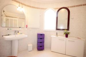 een witte badkamer met een wastafel en een spiegel bij Calypso in Jávea