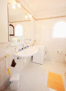 een witte badkamer met een wastafel en een spiegel bij Calypso in Jávea