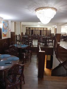 ein Restaurant mit Tischen und Stühlen und einem Kronleuchter in der Unterkunft Hotel Majestic City Center in Iaşi