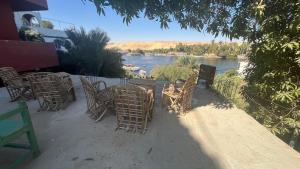 a group of chairs and tables with a view of a river at Anas Nubian Guest House in Aswan