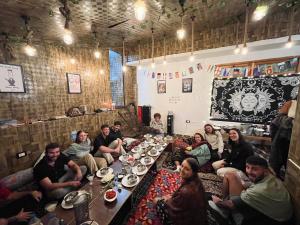 a group of people sitting around a table in a room at Yellowjackets Hostel Tosh in Tosh