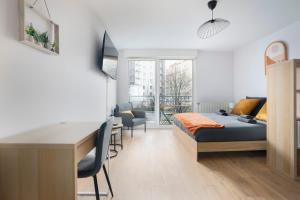 a bedroom with a bed and a desk with chairs at Le Cocon Lyonnais in Lyon