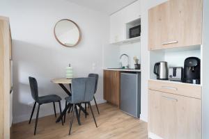 a kitchen with a table and chairs in a room at Le Cocon Lyonnais in Lyon