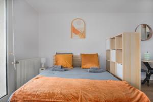 a bedroom with a bed with orange pillows and a desk at Le Cocon Lyonnais in Lyon +1 photo