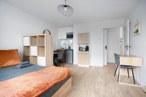 a bedroom with a bed and a desk and a kitchen at Le Cocon Lyonnais in Lyon