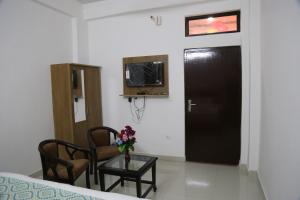 a room with a black door and a table and chairs at Hotel Yog Tapovan in Rishīkesh +5 photos
