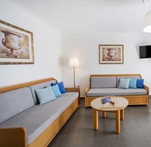 ein Wohnzimmer mit zwei Betten und einem Tisch in der Unterkunft Peridis Family Resort in Kos-Stadt