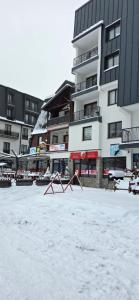 a snow covered parking lot in front of a building at Apartman Savic Jahorina in Jahorina