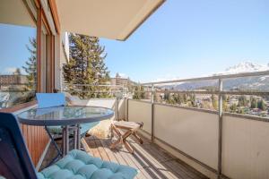 a balcony with a table and a laptop on it at Fortuna 4 by Arosa Vacations, Panoramablick auf die Berge und Parkplatz inklusive in Arosa