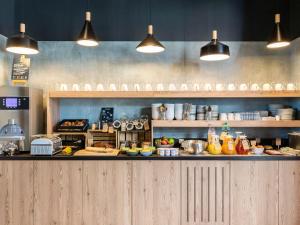 a kitchen with a counter with food on it at Aparthotel Adagio access Palaiseau Saclay in Palaiseau