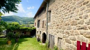 un vecchio edificio in pietra con un cortile accanto di Maison de charme avec studio indépendant a Saint-Prix