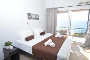 a bedroom with a large bed with a view of the ocean at Sunny views studios in Agios Gordios