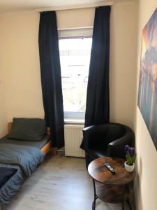 a bedroom with a bed and a chair and a table at Pension Karsten Mertens in Gardelegen