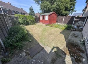une cour arrière avec un jardin et un abri de jardin rouge dans l'établissement Canterbury Luxe Stay, à Hackington
