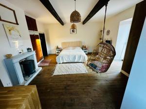 una camera con letto a dondolo e camino di Maison de charme avec studio indépendant a Saint-Prix