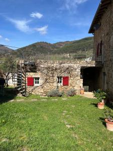una casa in pietra con porte rosse e un cortile di Maison de charme avec studio indépendant a Saint-Prix Altre 8 foto