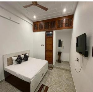 a bedroom with a bed and a flat screen tv at Hotel Shree Rameshwaram Near by All Temple in Ayodhya