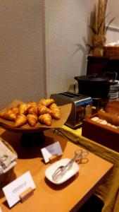 a table with a tray of croissants and a plate of bread at Hotel Bishops Arms Mora in Mora