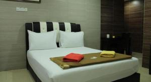 a large white bed with two towels on it at Serdang Business Hotel in Serdang