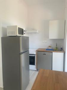 una cucina con frigorifero e forno a microonde. di villa Elaionas a Tsivarás