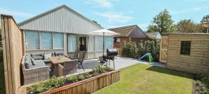 een achtertuin met een bank en een paraplu bij The Pelican in Schoorldam