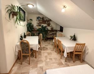 a dining room with white tables and wooden chairs at Pokoje Gościnne Stawiguda in Stawiguda