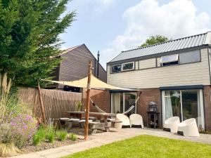 a house with a patio with a table and chairs at Strandbries in Warmenhuizen