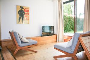 a living room with two chairs and a tv at Strandbries in Warmenhuizen