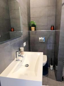a bathroom with a white sink and a toilet at Strandbries in Warmenhuizen +26 photos