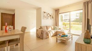 a living room with a couch and a table at Cavalo Preto Ocean Breeze Apartment in Forte Novo Quarteira in Quarteira