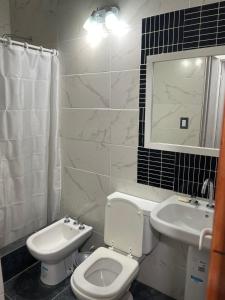 un bagno bianco con un water e un lavandino di Casa tinajas a Santiago del Estero Altre 5 foto