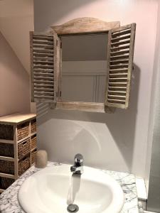 ein Badezimmer mit Waschbecken und Spiegel in der Unterkunft Maison à 5mn de Honfleur in Fourneville + 36 Fotos