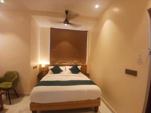 Un dormitorio con una cama con ventilador de techo. en Urban Suites, en Bangalore