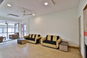ein Wohnzimmer mit zwei Stühlen und einer Couch in der Unterkunft Hotel O Mayura in Ankleshwar