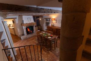 ein Wohnzimmer mit Tisch und Kamin in der Unterkunft L'Oustal du Larzac, gîte en Aveyron in La Bastide-Pradines