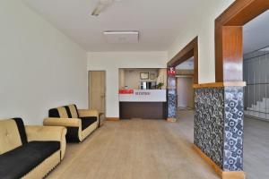 ein Wohnzimmer mit 2 Sofas und einer Küche in der Unterkunft Hotel O Mayura in Ankleshwar