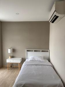 a bedroom with a large bed and a white table at Spacious 3BR near Impact, Don Mueang Airport & Pink Line MRT in Nonthaburi +13 photos