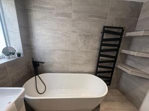 een badkamer met een wit bad en een ladder bij Dalton House - Private Parking in Blackpool +34 foto's