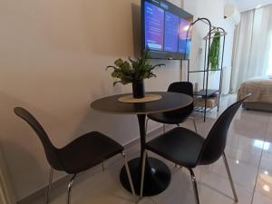 a dining room with a table and chairs and a tv at Molly Downtown Thessaloniki in Thessaloniki