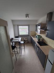 een kleine keuken met een tafel en stoelen erin bij F2 cozy centre ville proche bale et tram in Saint-Louis