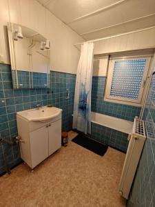 een badkamer met een wastafel en een toilet en een raam bij F2 cozy centre ville proche bale et tram in Saint-Louis