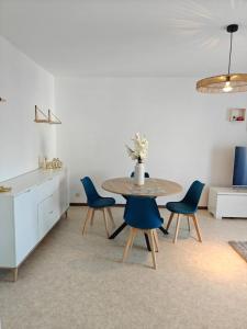 een eetkamer met een tafel en blauwe stoelen bij F2 cozy centre ville proche bale et tram in Saint-Louis