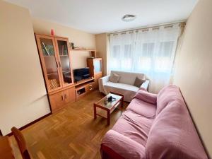 ein Wohnzimmer mit einer Couch und einem Sessel in der Unterkunft Cómodo apartamento con piscina by beBalmy in OVD