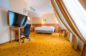 a bedroom with a desk and a bed and a television at Ibercity Wien Schönbrunn in Vienna