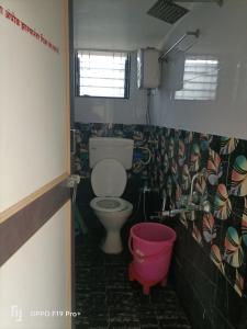 ein Badezimmer mit einem WC und einem rosa Eimer in der Unterkunft guest house Akshay in Akalkot + 12 Fotos
