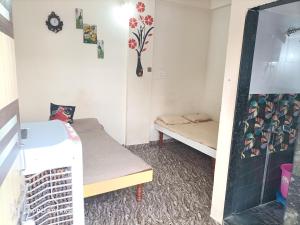 ein kleines Zimmer mit einem Bett und einem Spiegel in der Unterkunft guest house Akshay in Akalkot