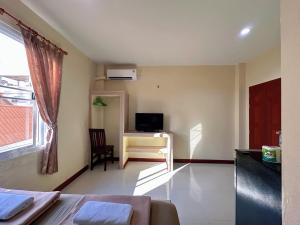a living room with a desk and a television at Pepa Guest House in Ko Tao