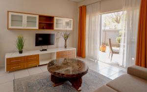 Una sala de estar con una mesa de café y un televisor. en Apartments @ 125, en Gaborone