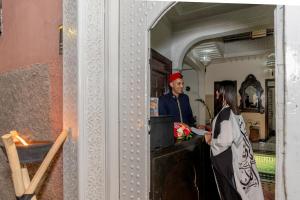 een man en een vrouw die aan een balie staan bij Riad HAFSSA & Spa in Marrakesh